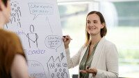 Frau mit Stift an beschriebener Scheibe